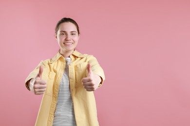 Happy woman showing thumbs up on pink background, space for text. Like gesture