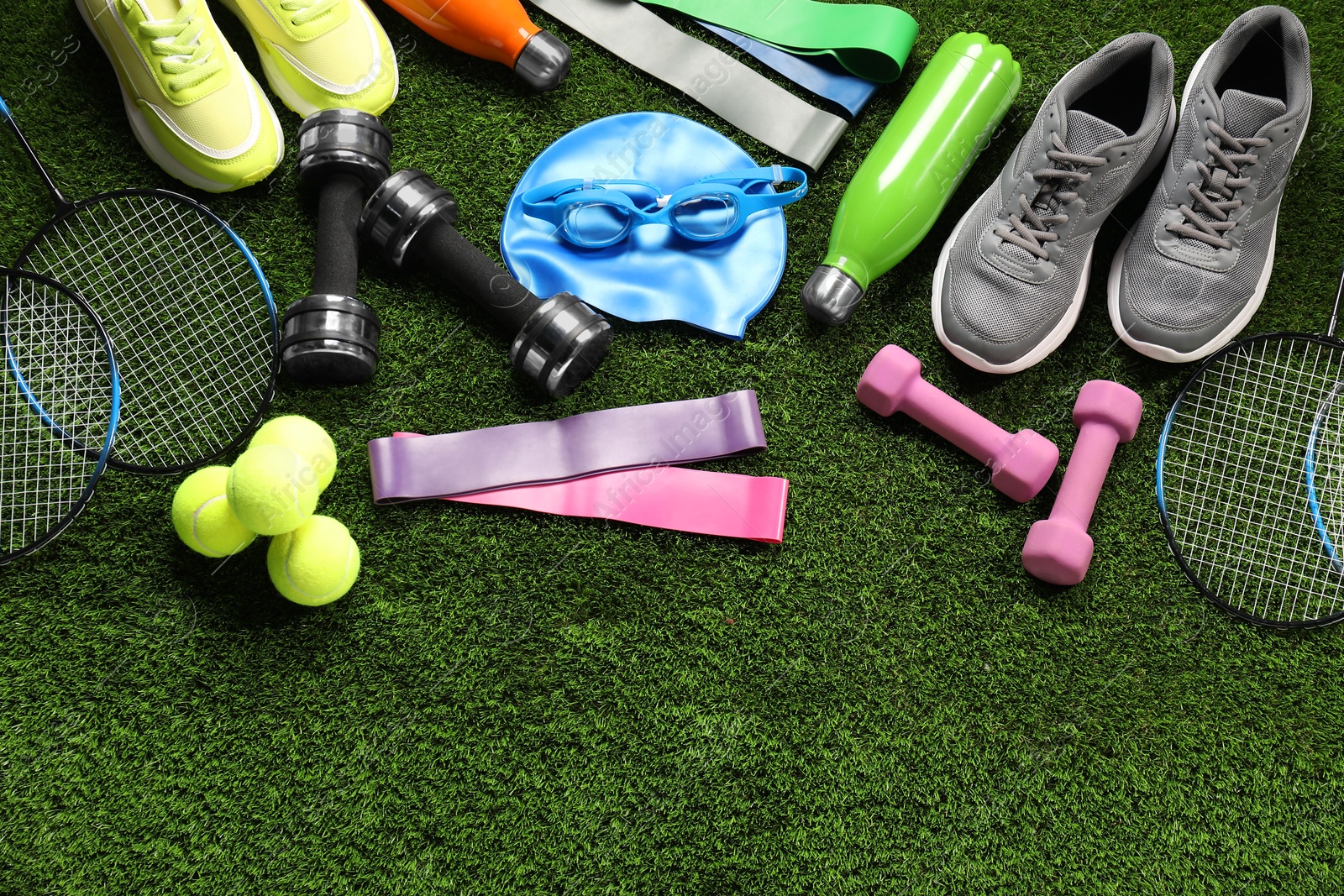 Photo of Different sports equipment on artificial grass, flat lay