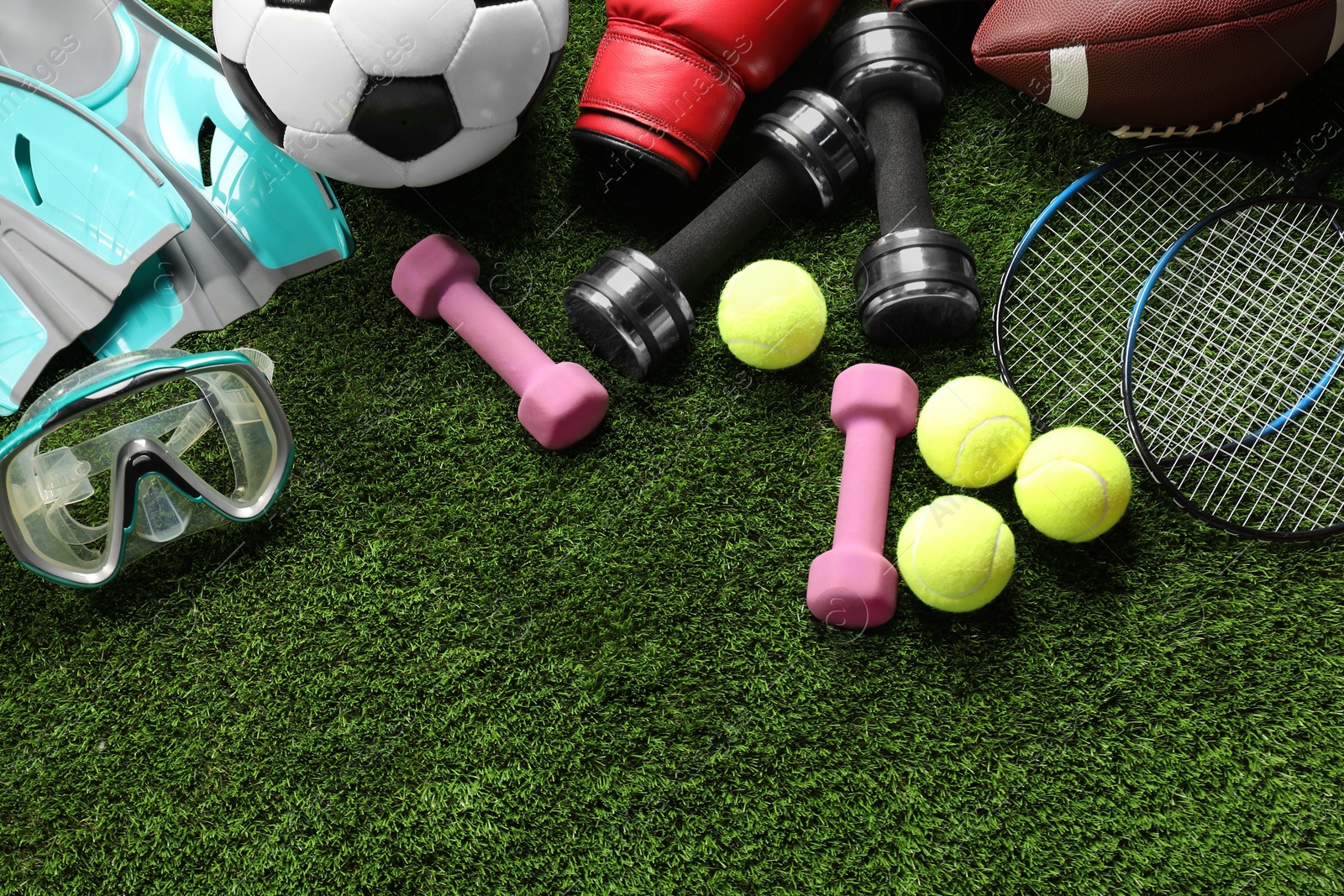 Photo of Different sports equipment on artificial grass, flat lay. Space for text