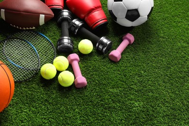 Photo of Different sports equipment on artificial grass, flat lay. Space for text