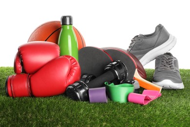 Photo of Different sport equipment on artificial grass isolated on white