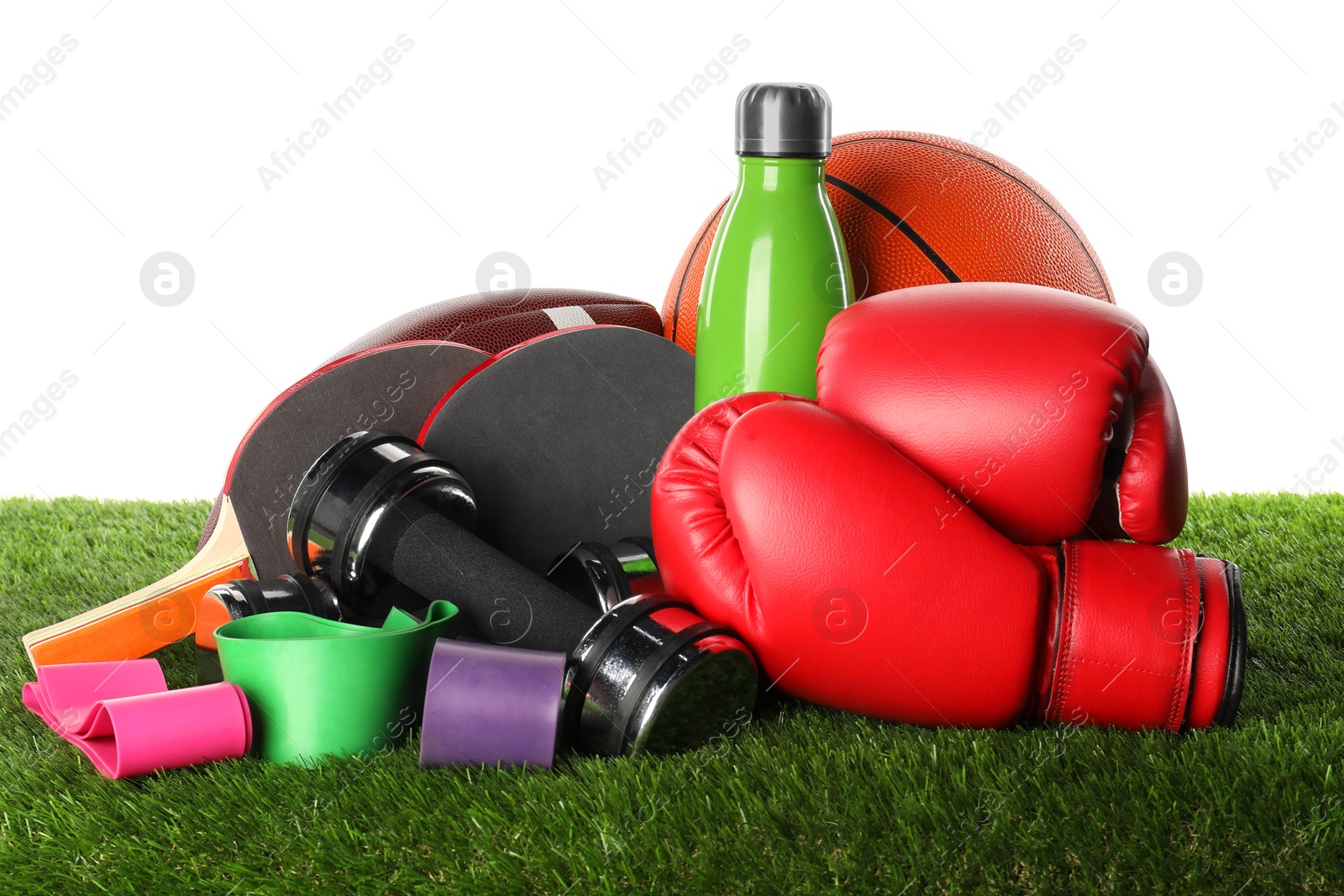 Photo of Different sport equipment on artificial grass isolated on white