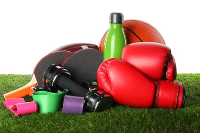 Photo of Different sport equipment on artificial grass isolated on white