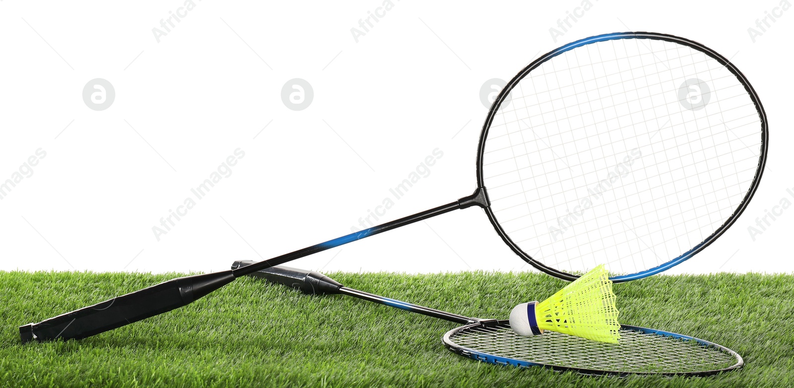 Photo of Badminton rackets and shuttlecock on artificial grass isolated on white. Sport equipment