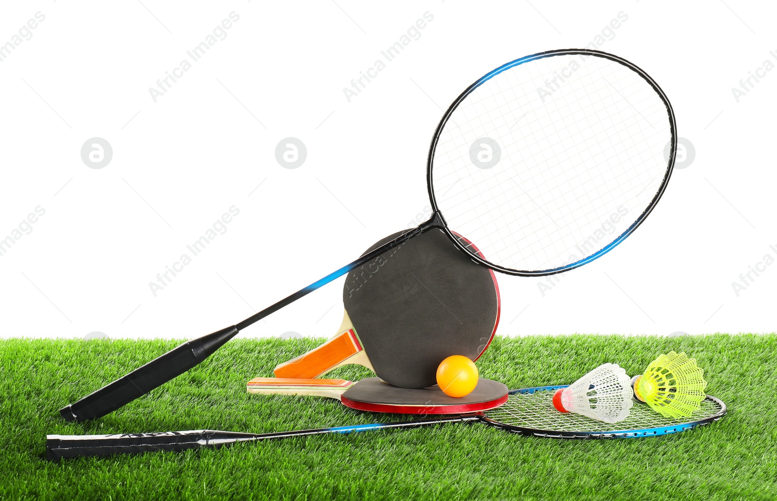 Photo of Different sport equipment on artificial grass isolated on white