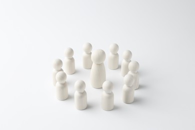 Photo of Big human figure among smaller ones on white background. Competition concept