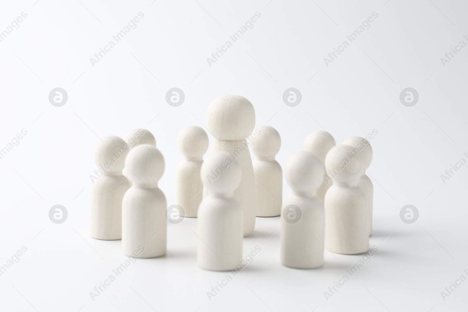 Photo of Big human figure among smaller ones on white background. Competition concept