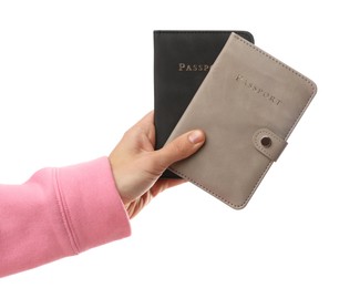 Photo of Woman holding passports in bright covers on white background, closeup