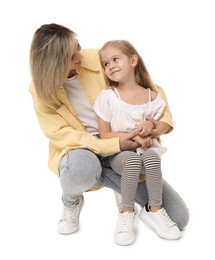 Happy mother and her cute little daughter on white background