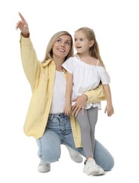 Photo of Happy mother and her cute little daughter pointing at something on white background