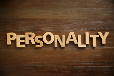 Photo of Word Personality made of letters on wooden table, top view