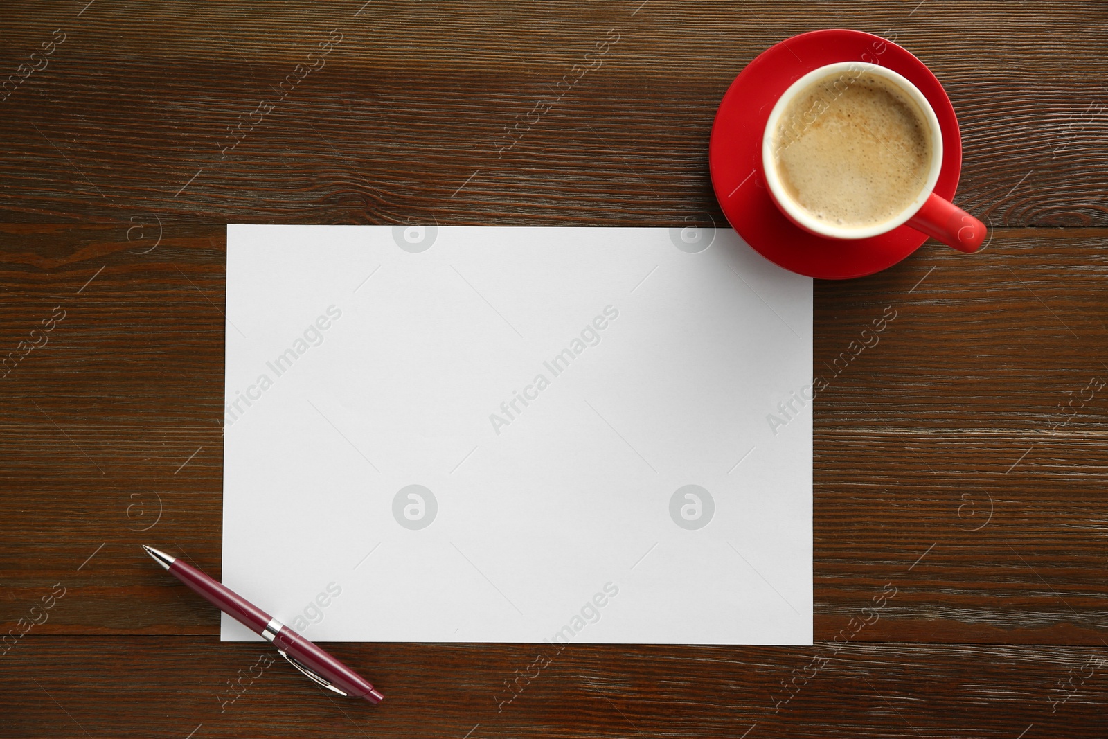 Photo of Blank paper, pen and coffee on wooden table, top view. Space for text