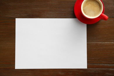 Photo of Blank paper and coffee on wooden table, top view. Space for text