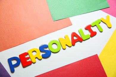 Photo of Word Personality made of letters on color background, top view