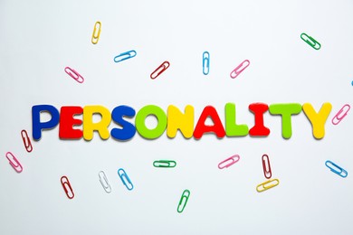 Photo of Word Personality made of colorful letters and paper clips on white background, top view