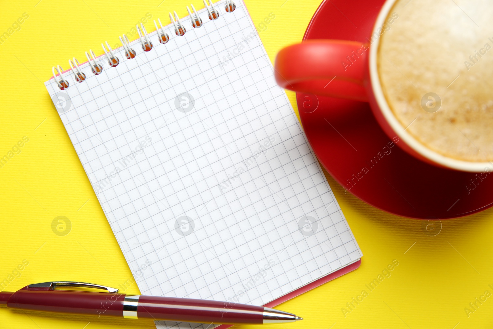 Photo of Blank notebook, coffee and pen on yellow background, flat lay. Space for text