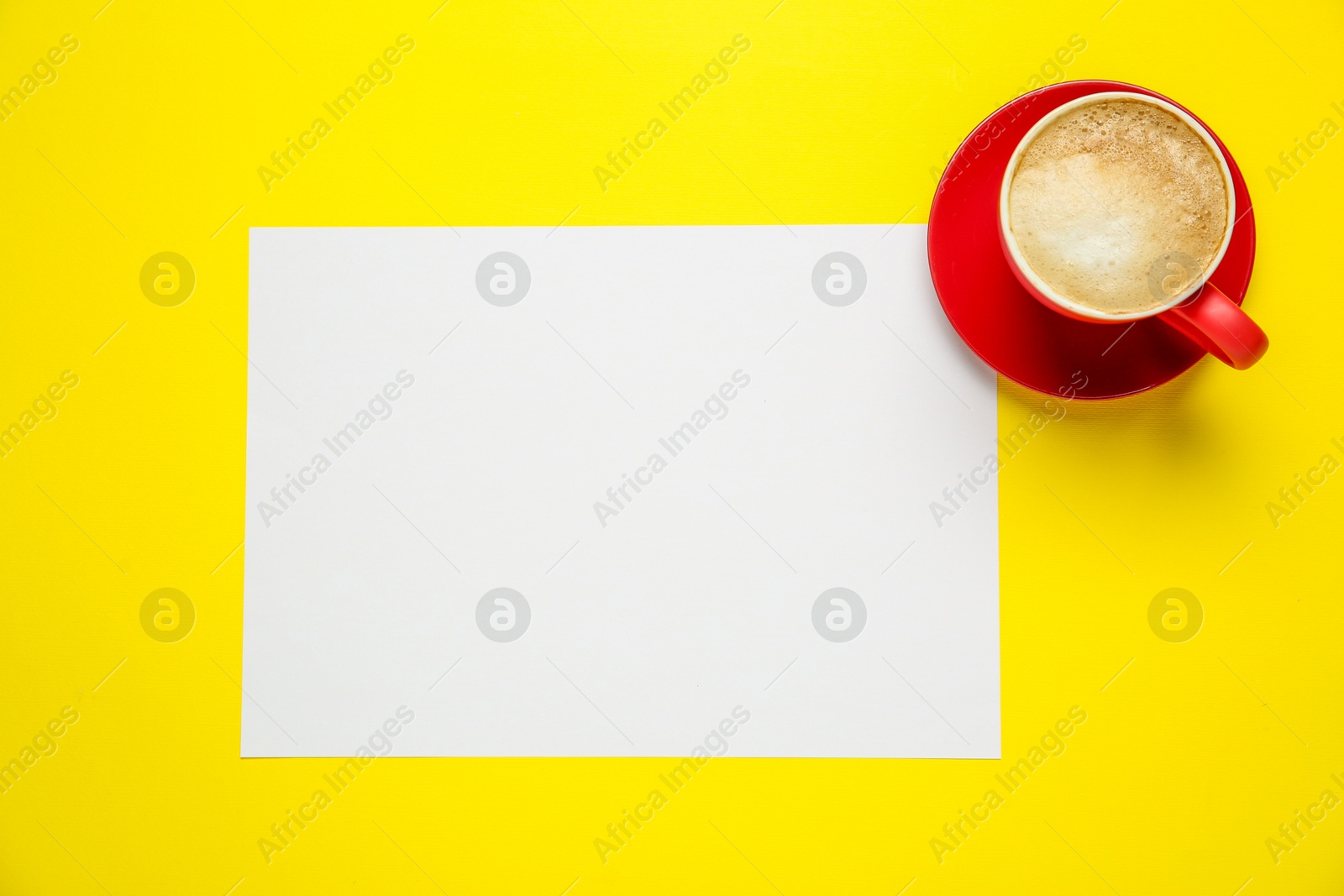 Photo of Blank paper and coffee on yellow background, top view. Space for text