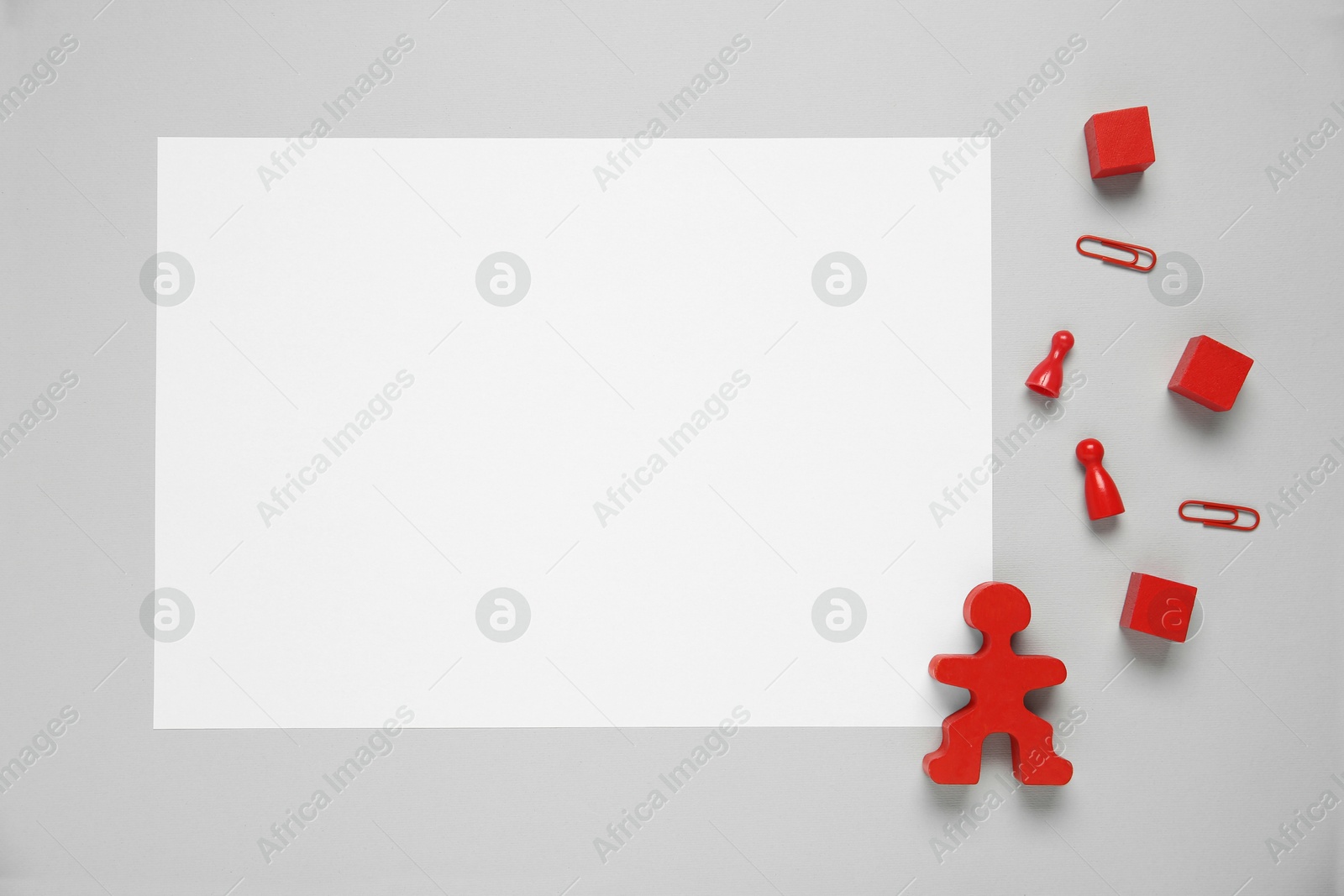 Photo of Blank paper sheet and human figure on light grey background, flat lay. Space for text