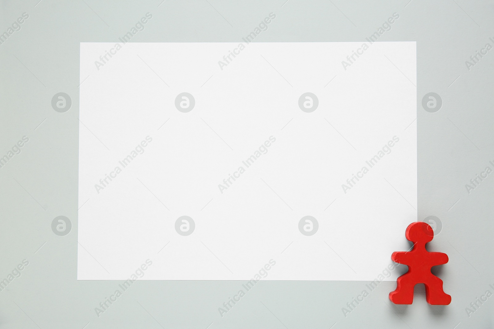 Photo of Blank paper and human figure on light grey background, top view. Space for text