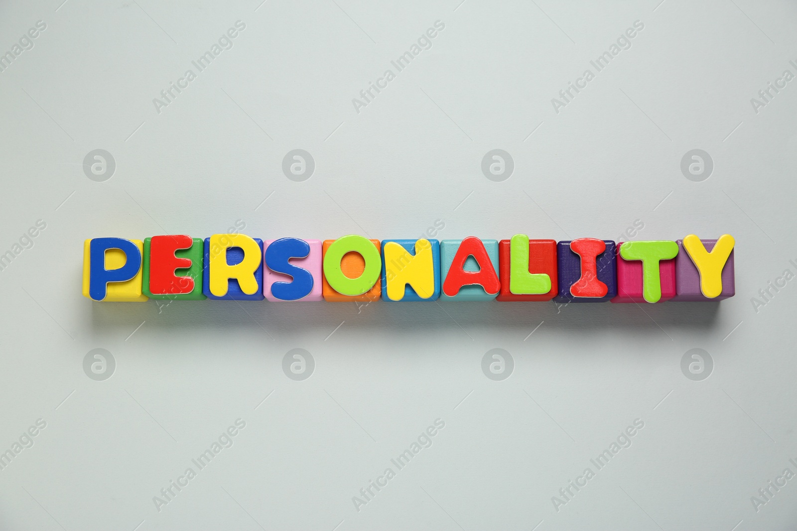 Photo of Word Personality made of colorful letters on light grey background, top view