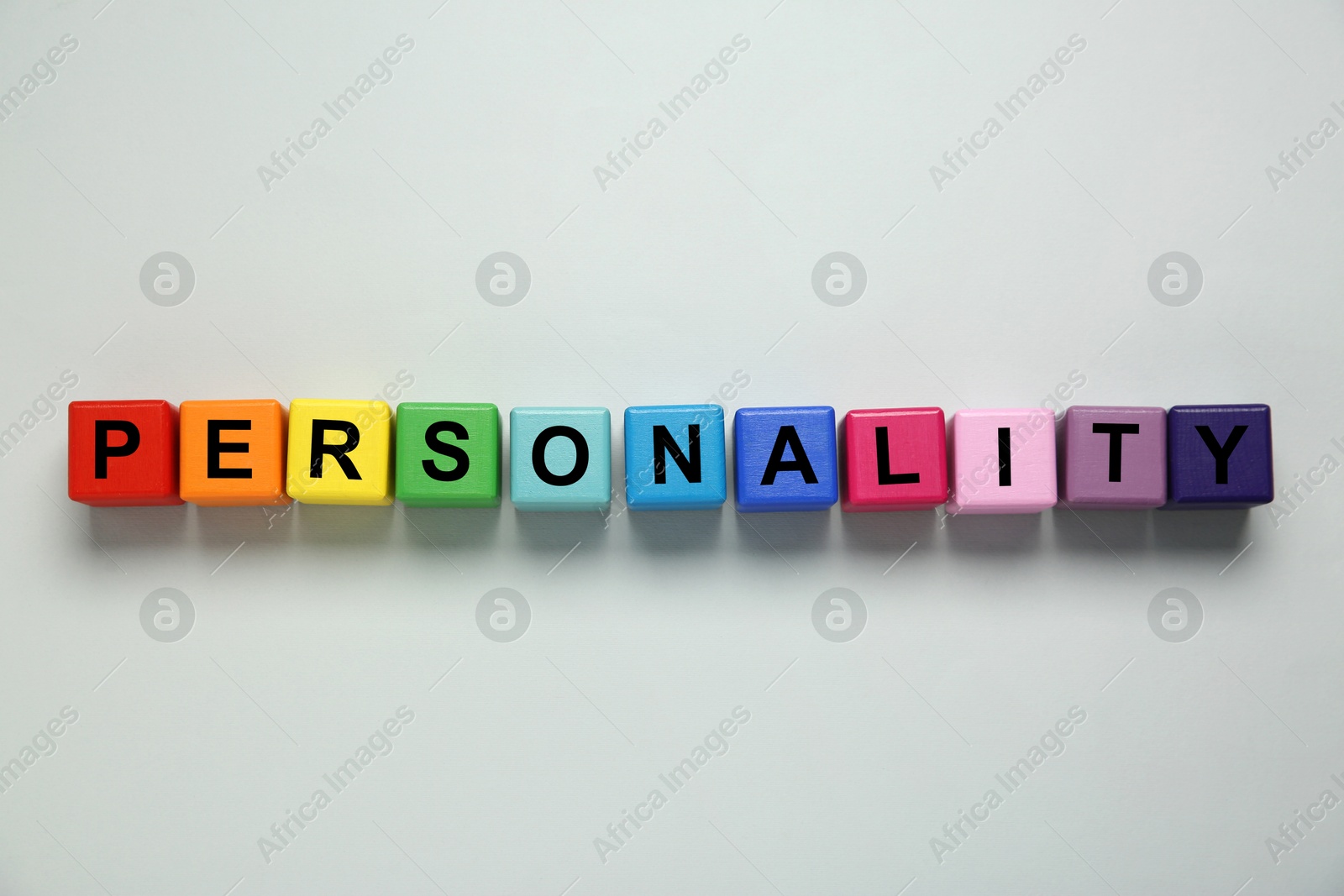 Photo of Word Personality made of colorful cubes with letters on light grey background, top view