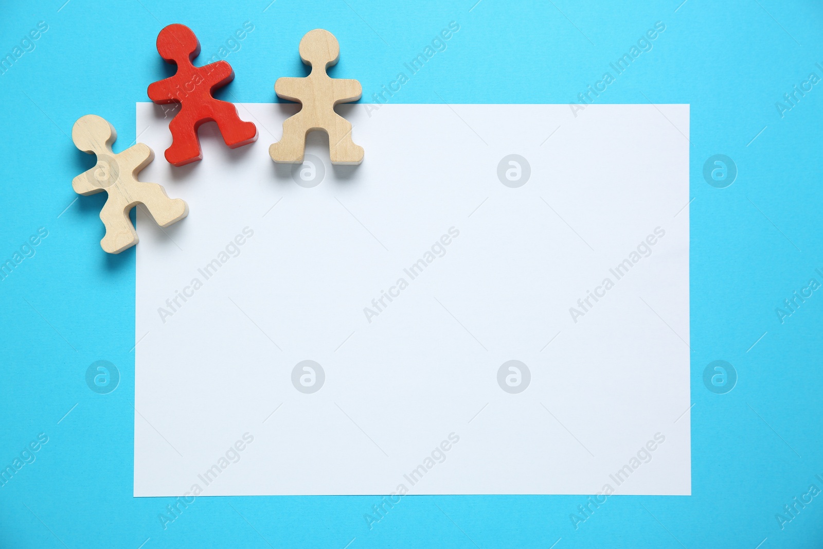 Photo of Blank paper sheet and human figures on light blue background, flat lay. Space for text