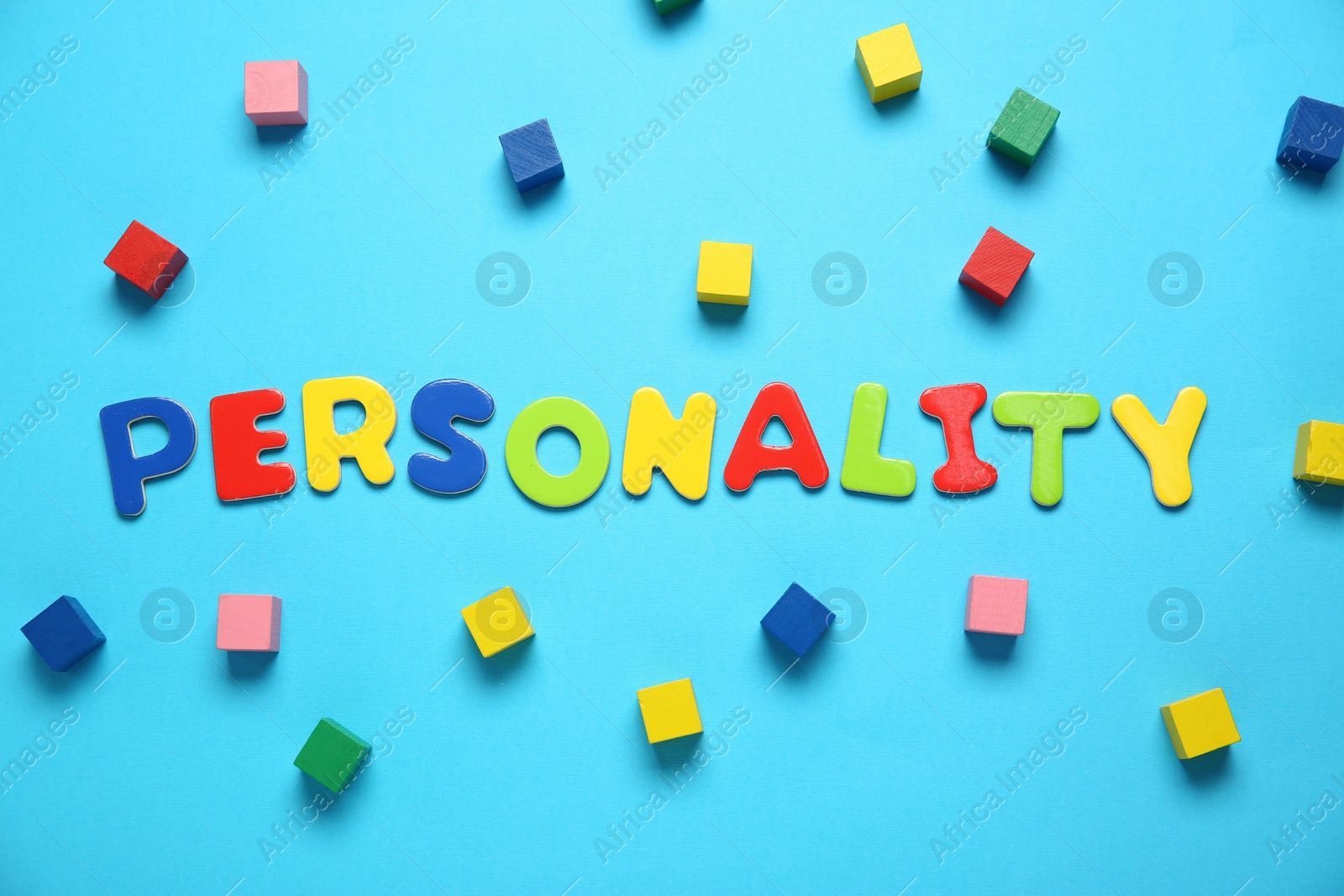 Photo of Word Personality made of colorful letters and cubes on light blue background, flat lay