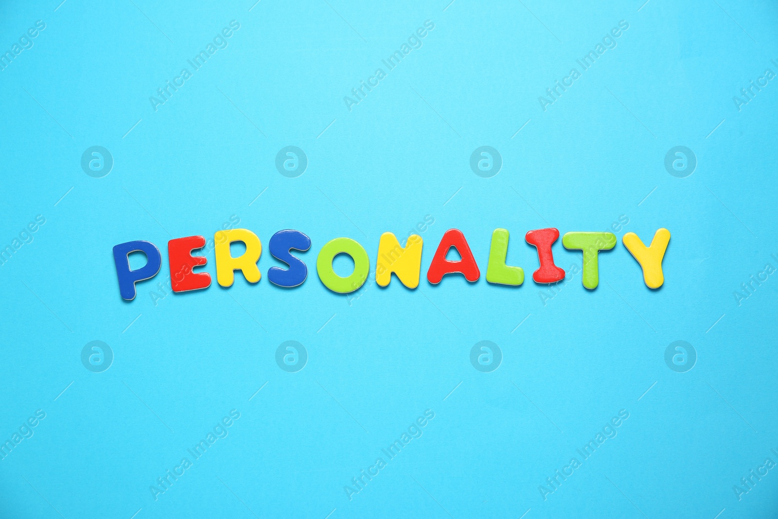 Photo of Word Personality made of colorful letters on light blue background, top view