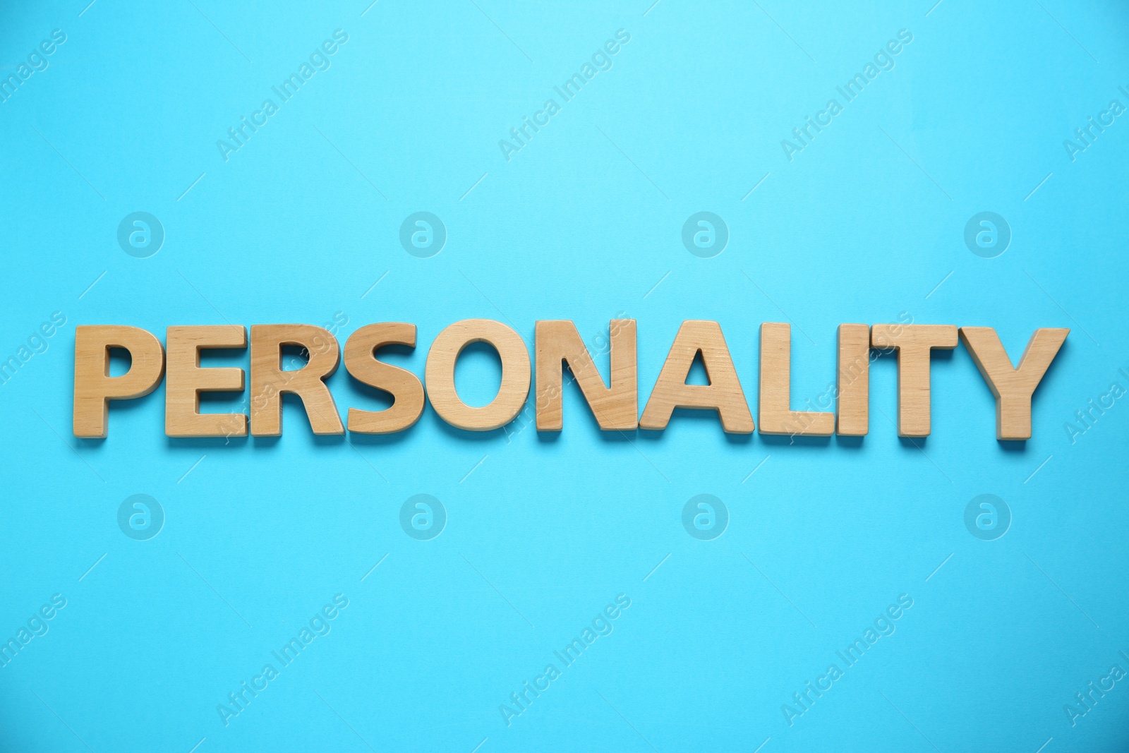 Photo of Word Personality made of wooden letters on light blue background, top view