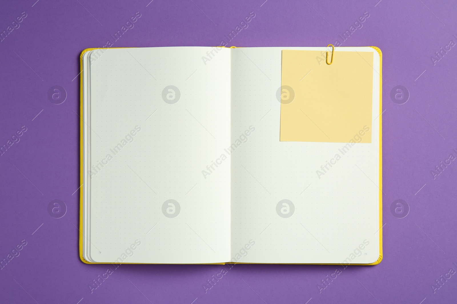 Photo of Blank notebook with note on purple background, top view. Space for text