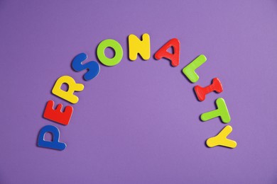 Photo of Word Personality made of colorful letters on purple background, top view