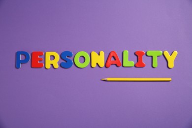 Photo of Word Personality made of colorful letters and pencil on purple background, top view