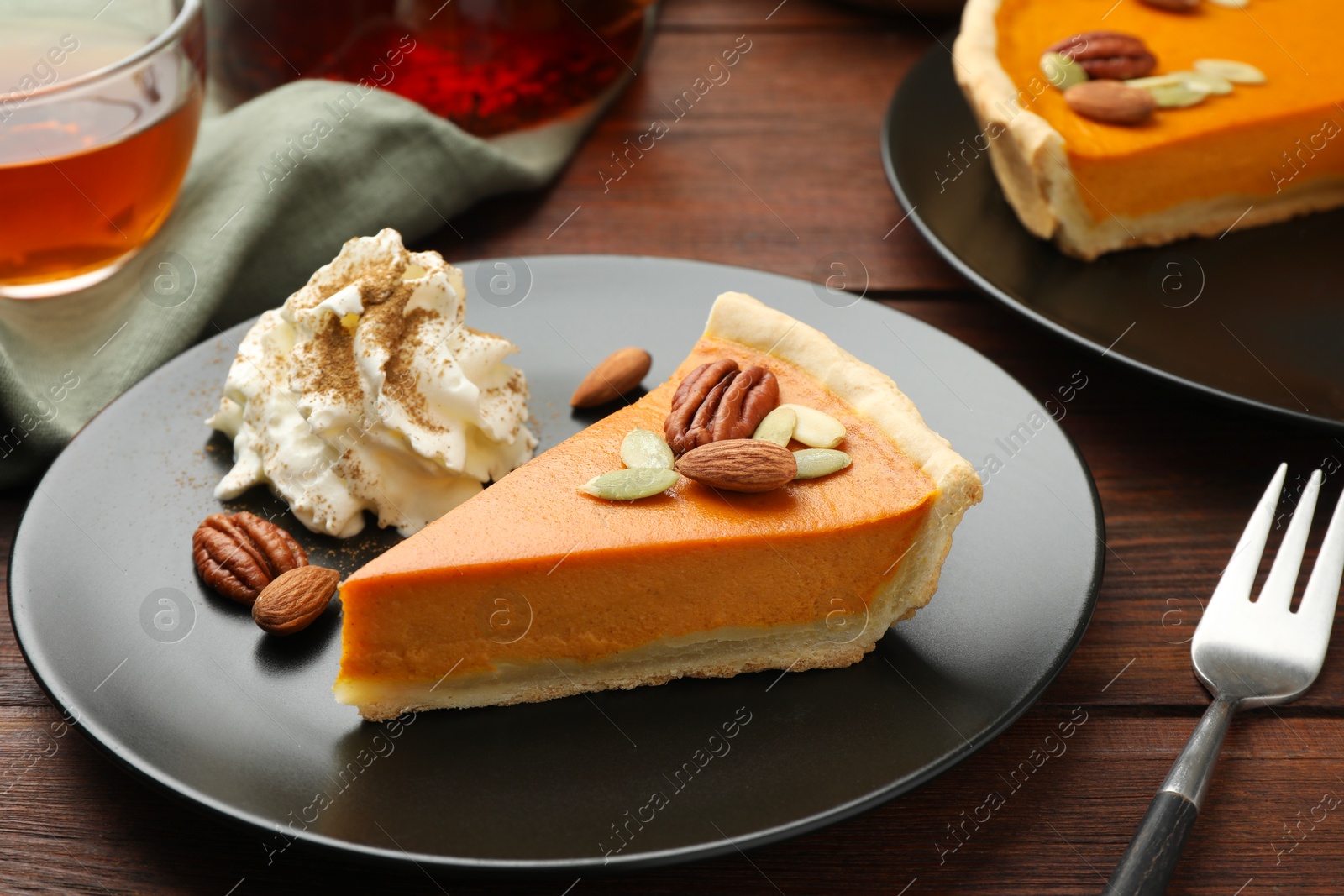 Photo of Piece of tasty homemade pumpkin pie served on wooden table, closeup