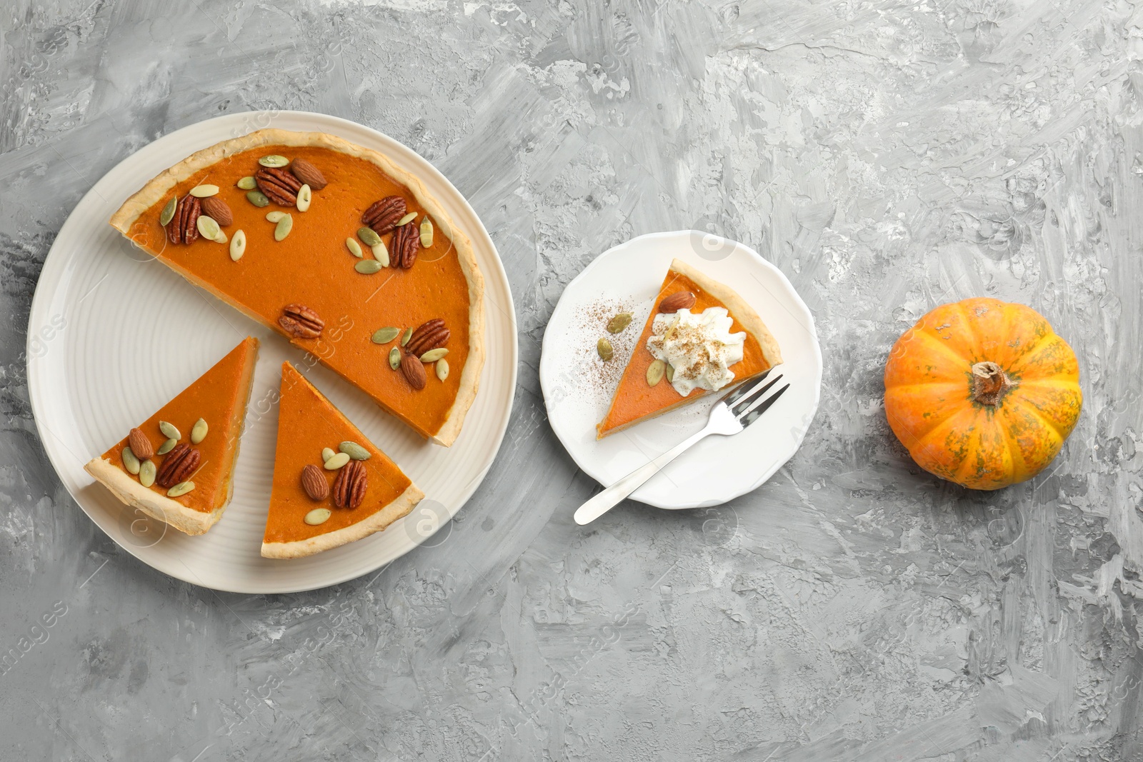 Photo of Pieces of tasty homemade pumpkin pie served on grey table, top view