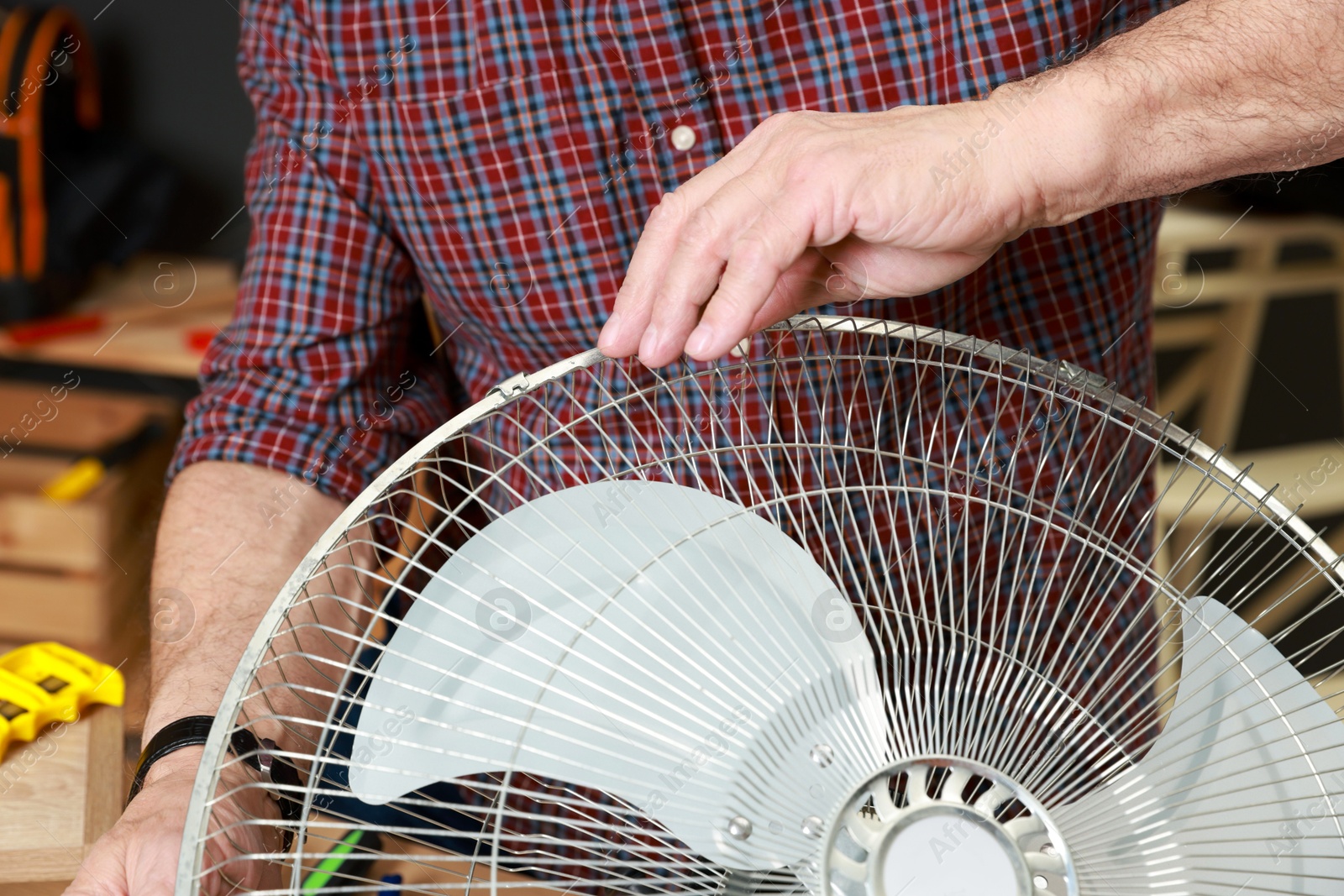 Photo of Relaxing hobby. Senior man repairing fan in workshop, closeup