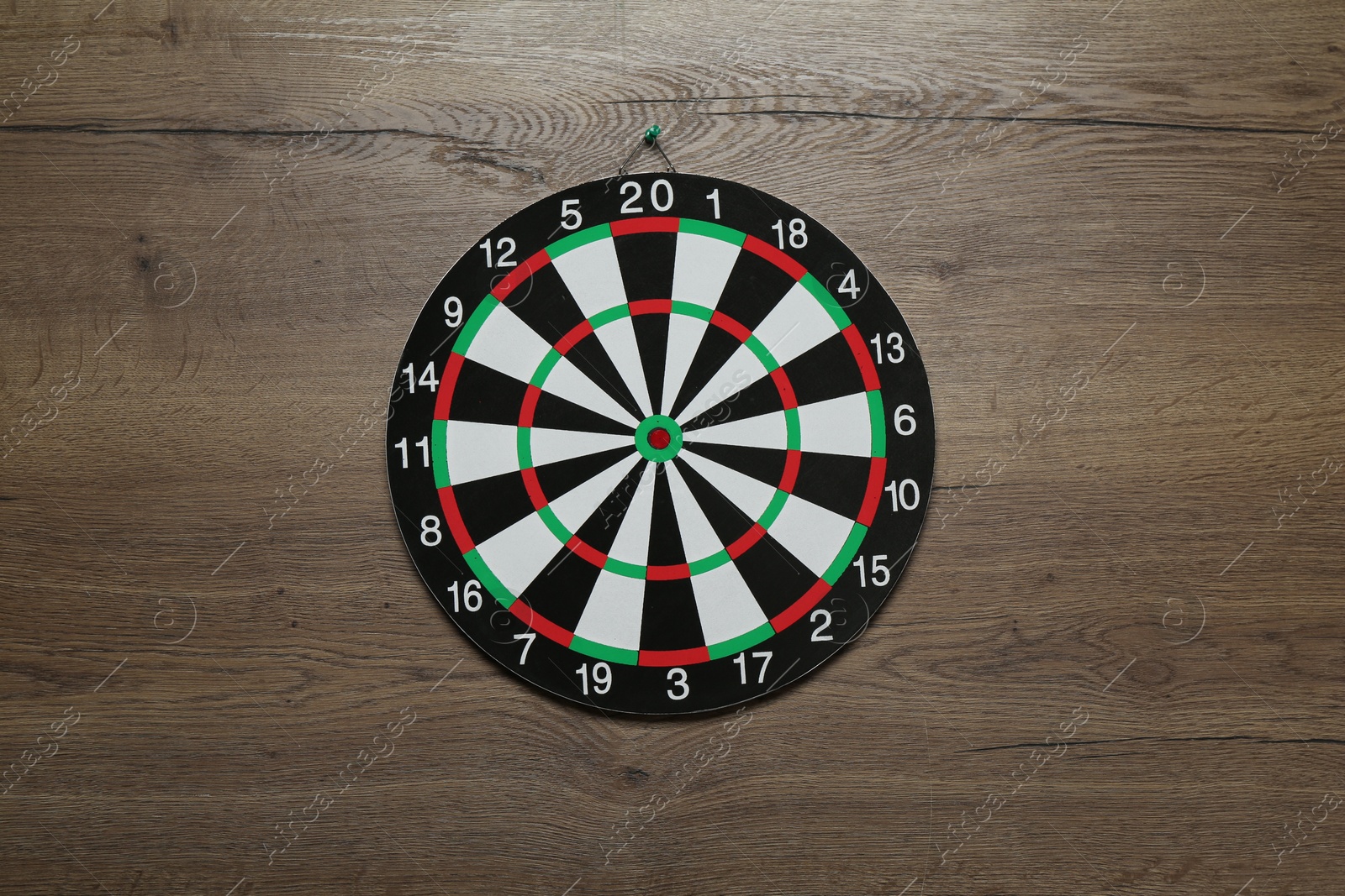 Photo of One dart board hanging on wooden background