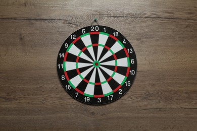 Photo of One dart board hanging on wooden background