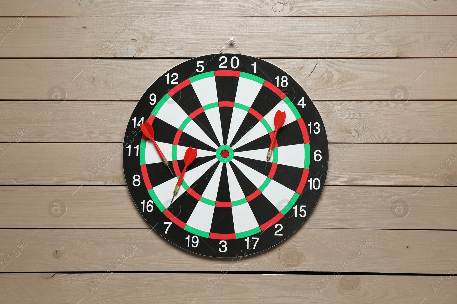 Photo of Dart board and arrows on wooden background, top view