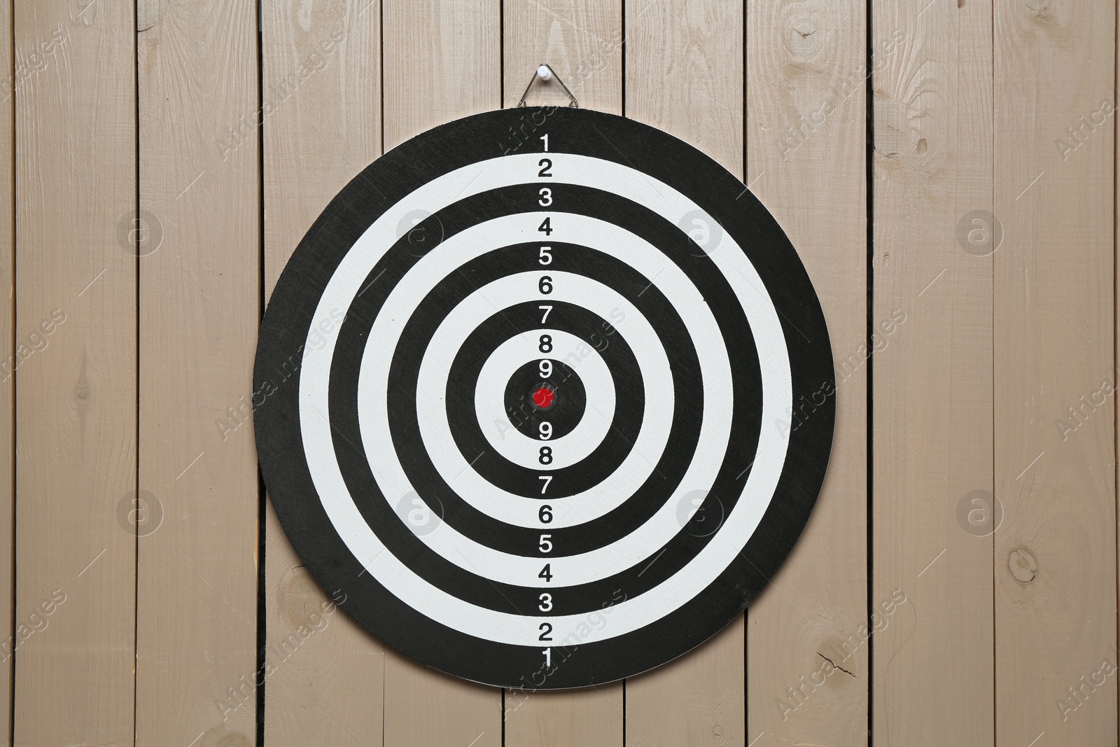 Photo of One dart board hanging on wooden background