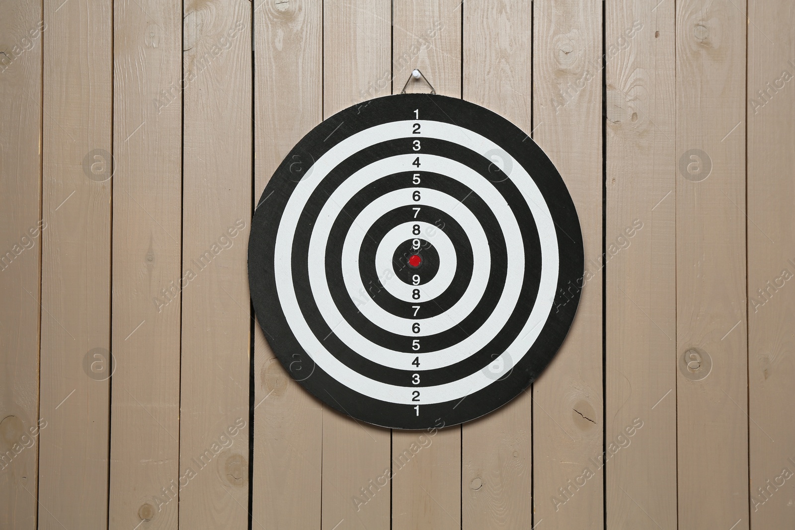 Photo of One dart board hanging on wooden background