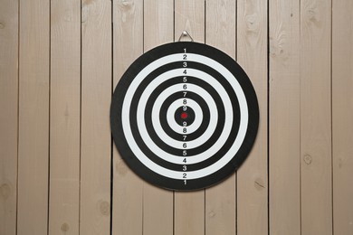 Photo of One dart board hanging on wooden background