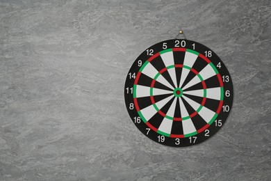 Photo of One dart board hanging on grey marble wall, space for text