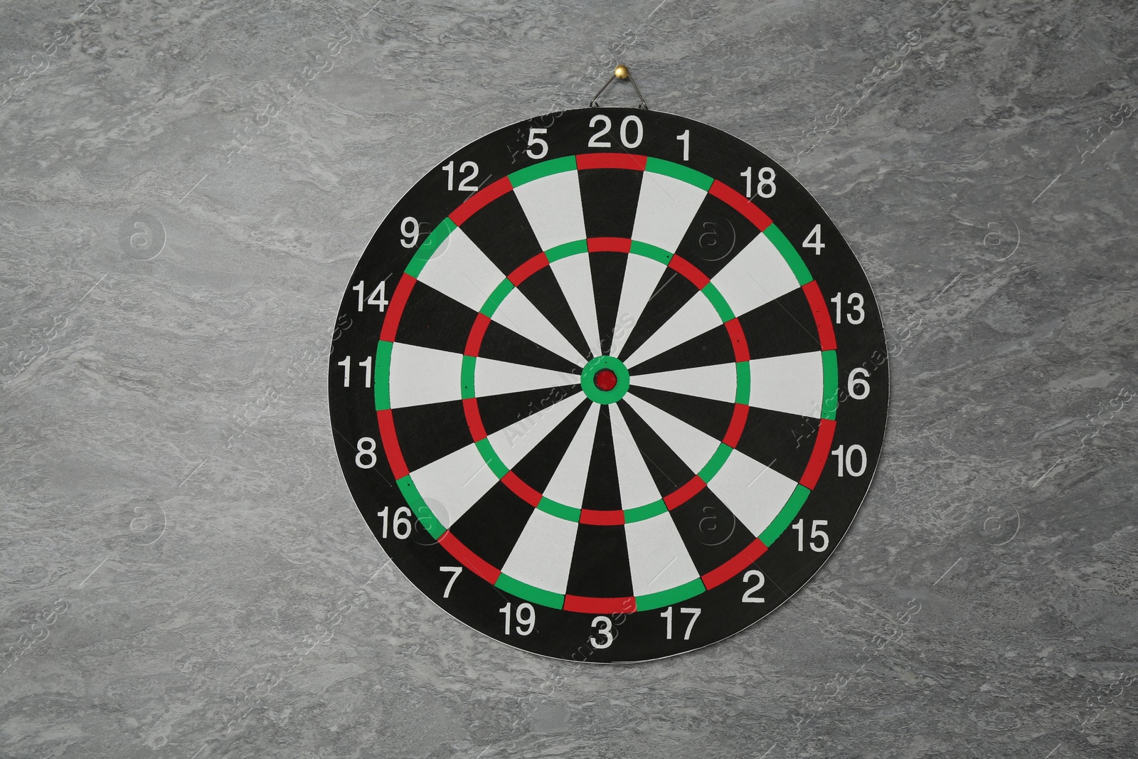 Photo of One dart board hanging on grey marble wall