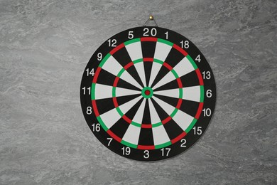 Photo of One dart board hanging on grey marble wall