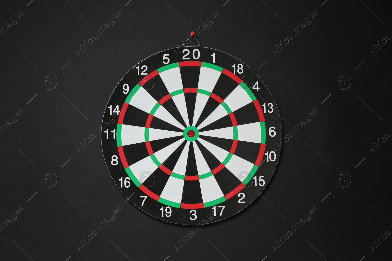 Photo of One dart board hanging on black wall