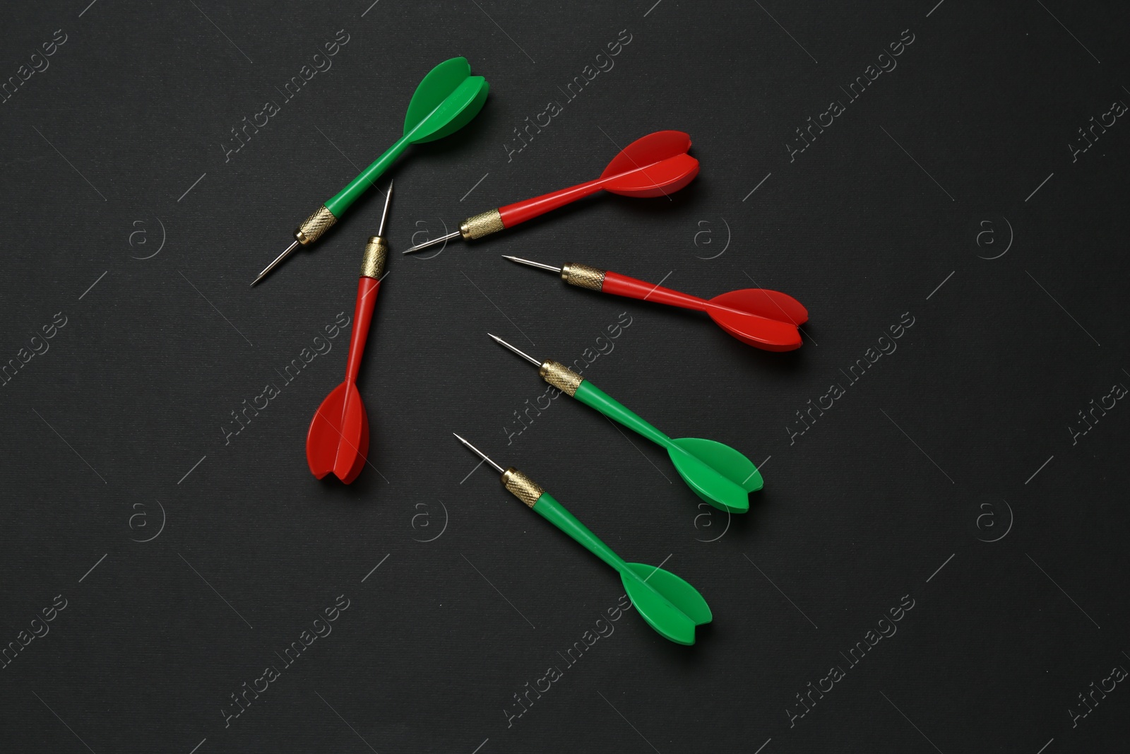 Photo of Colorful dart arrows on black background, flat lay