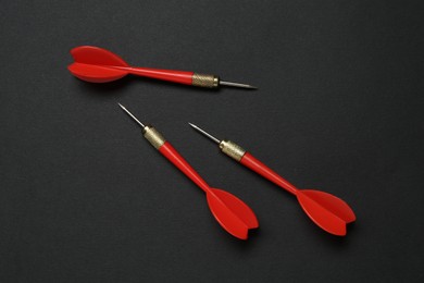 Photo of Red dart arrows on black background, flat lay