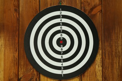 Photo of One dart board hanging on wooden background