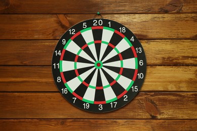 Photo of One dart board hanging on wooden background