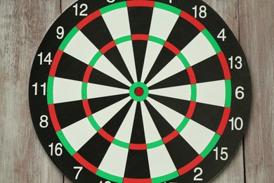 Photo of One dart board hanging on wooden rustic background